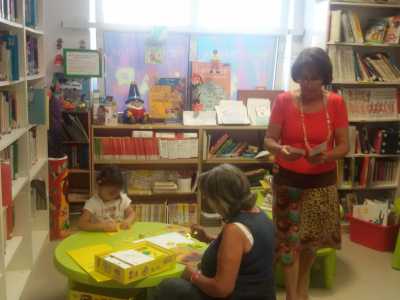 Una giovane lettrice assieme a due volontarie dell'associazione. In piedi c'� Fiorella Mastromarino, la coordinatrice della biblioteca